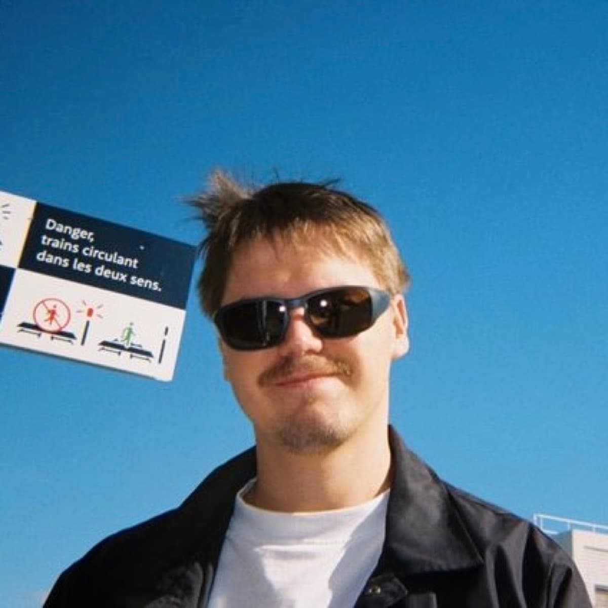 Dmitry Babichev in sunglasses under a blue sky